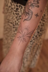 Fine line celestial hand tattoo featuring stars, crescent moon, and dainty dots