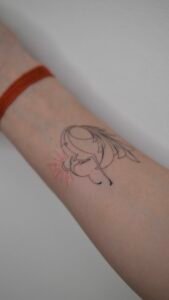 Blue ink ornamental tattoo inspired by azulejo Portuguese tile patterns, featuring a symmetrical diamond-shaped design with intricate fine-line scrolls and floral motifs on the skin