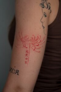 Small fineline skull tattoo with floral mandala detail on thigh