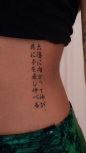 Black linework handpoke water lily tattoo on the wrist