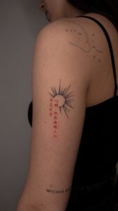 Micro color realism autumn maple leaf tattoo in orange and yellow on inner arm