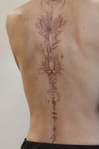 Black linework handpoke water lily tattoo on the wrist