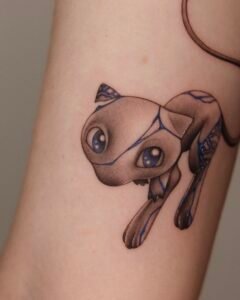 Unique fine-line Mew Pokémon tattoo on the inner arm featuring blue porcelain-style patterns and delicate shading