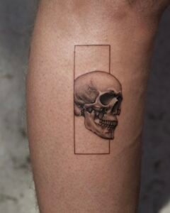 Anatomical skull tattoo in realistic black and grey style framed within a vertical rectangle on forearm, Names Tattoo Studio in Lisbon