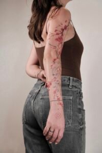 Black linework handpoke water lily tattoo on the wrist