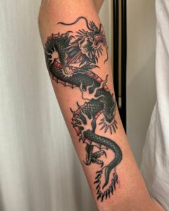 Small fineline skull tattoo with floral mandala detail on thigh