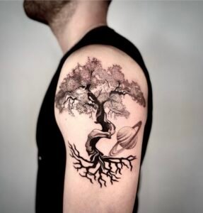 Black and grey surrealist tree of life tattoo with planet Saturn on upper arm