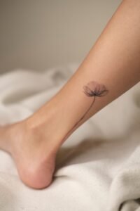 Black linework handpoke water lily tattoo on the wrist