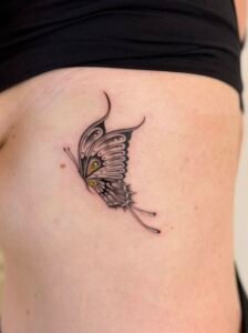 Black linework handpoke water lily tattoo on the wrist