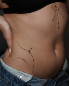 Micro color realism Monstera leaf tattoo with green and red variegation on inner forearm